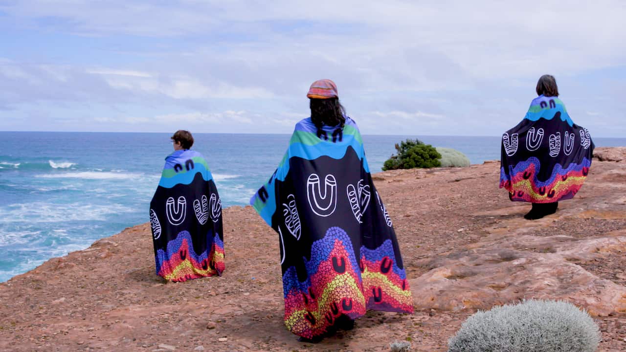 Women wearing the shawls looking out over the ocean