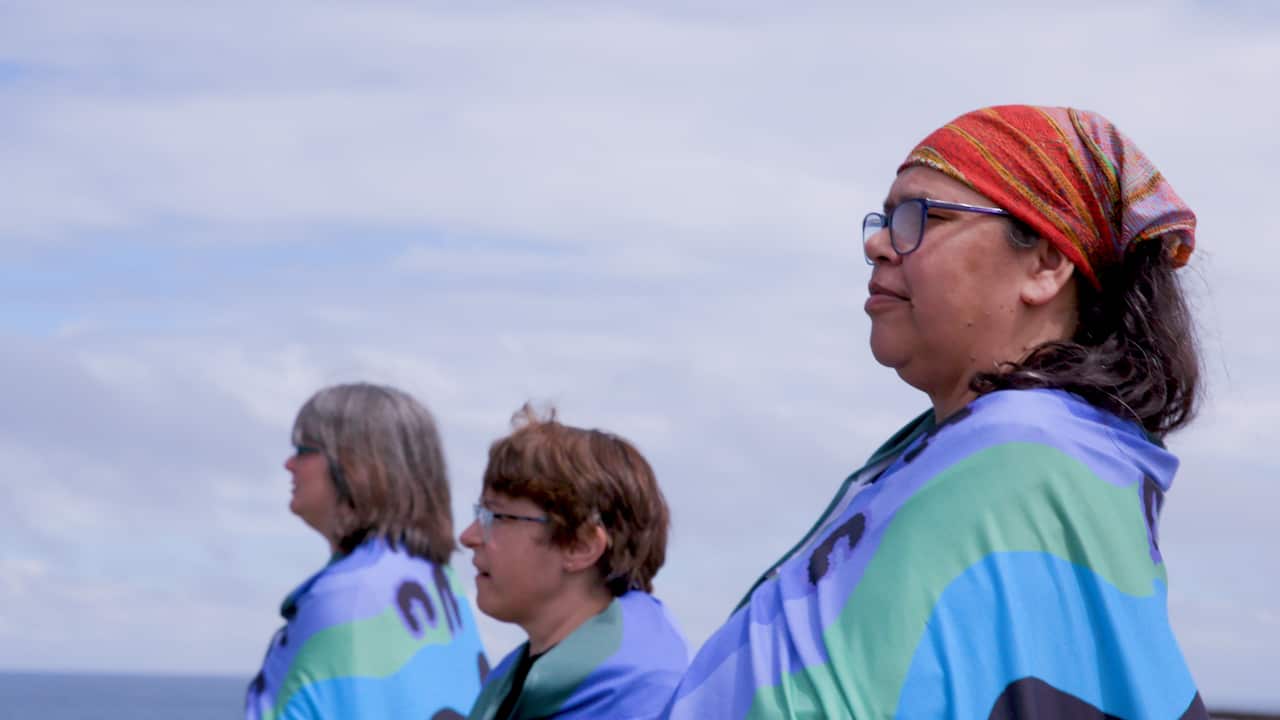 Women wearing the shawls looking out over the ocean