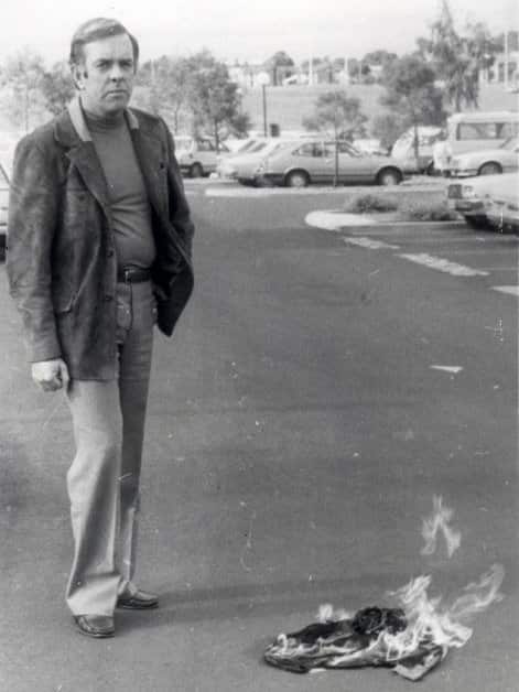 Shoalhaven Councillor Greg Watson standing next to a burning Aboriginal flag in a 'media stunt' in 1982.