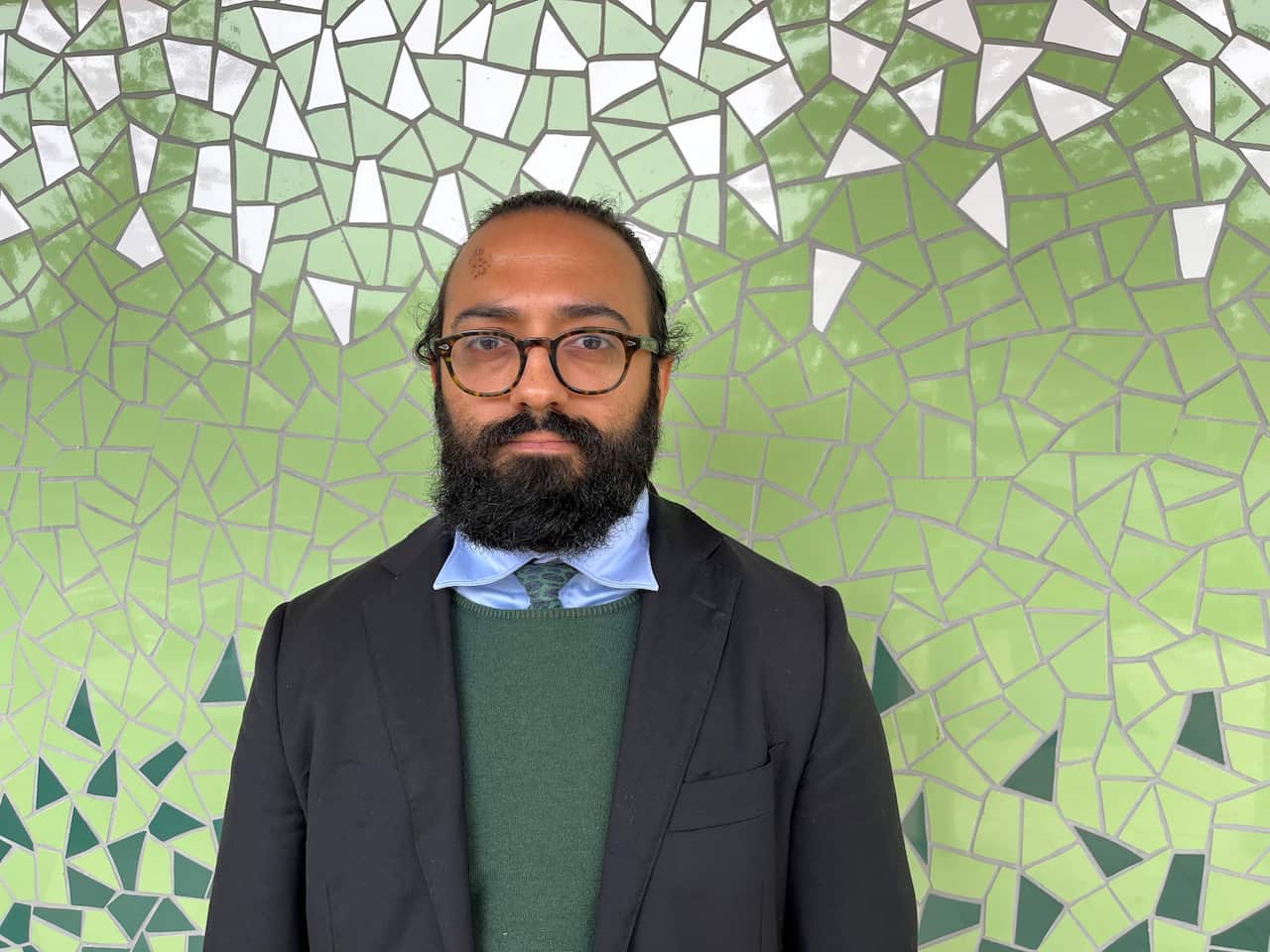 A man is wearing glasses and suit