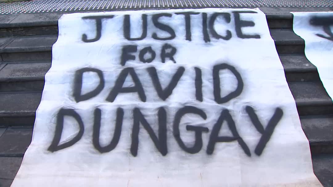 A banner on the steps of the Downing Centre.