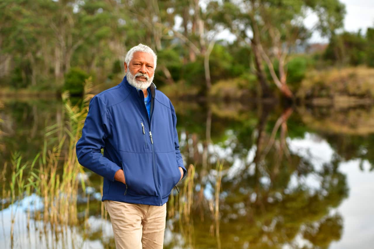Ernie Dingo stands in front of a river in a scene from Going Places.