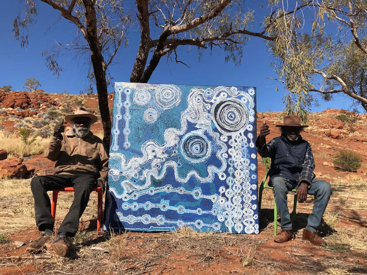 Taylor Wanyima Cooper and Witjiti George with their collaborative painting, 2021, Fregon, South Australia; Courtesy the artists and Kaltjiti Arts