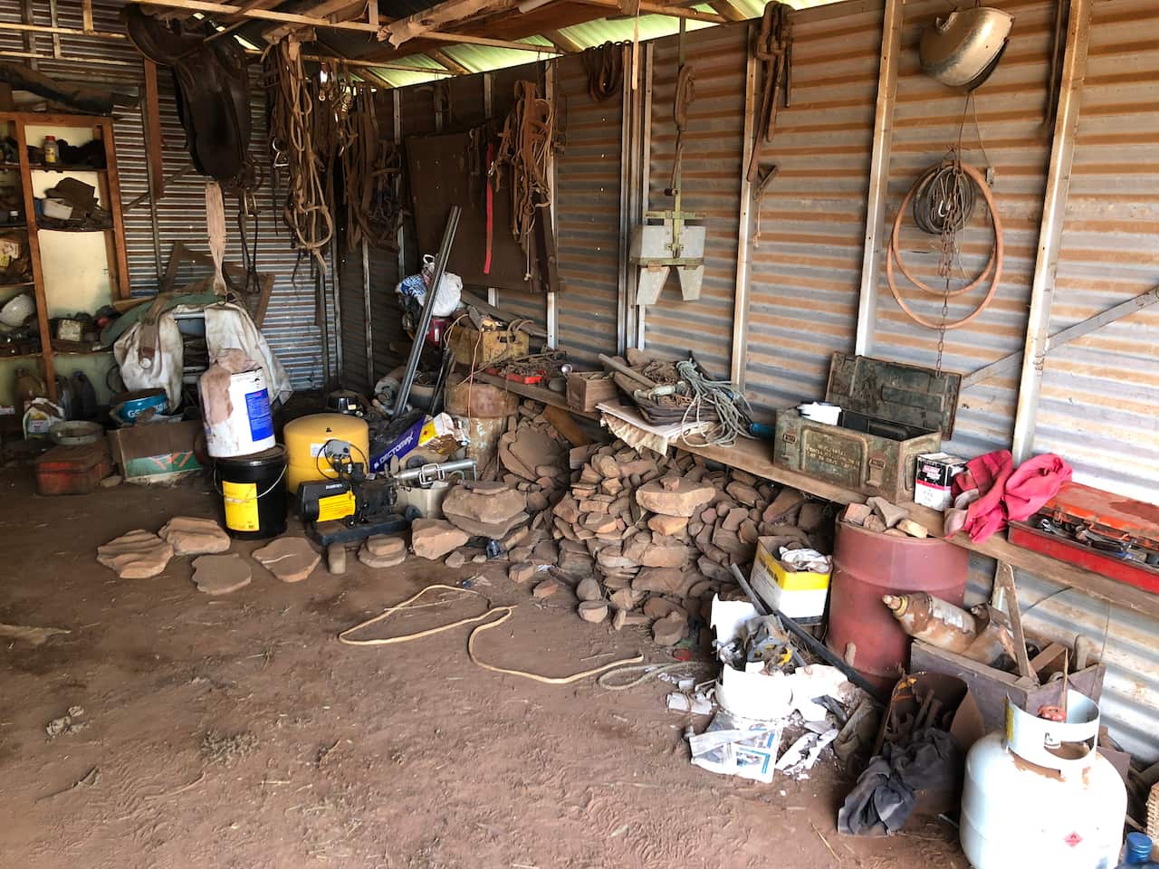 Farm shed with stone artefacts piled up. 