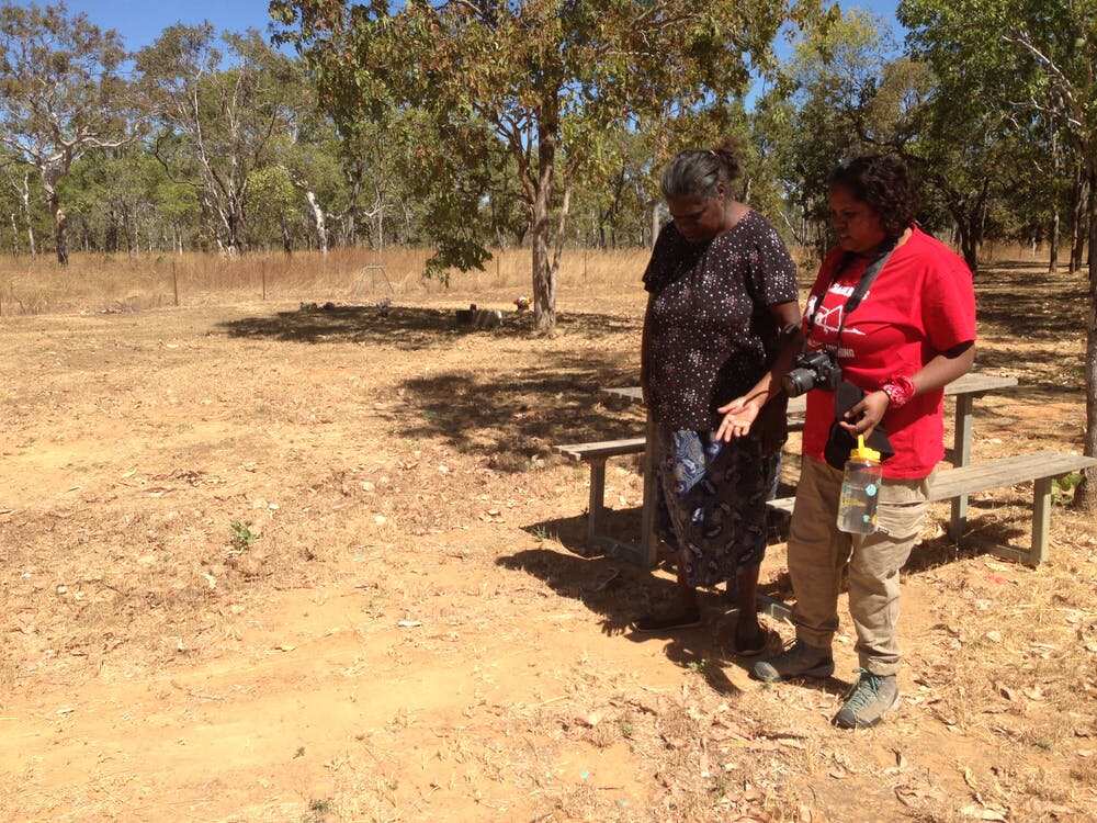 Jasmine Willika (right) with her mother, Rachael Kendino, try to identify graves at Barunga, which include Jasmine’s sister and her grandmother. (Claire Smith)