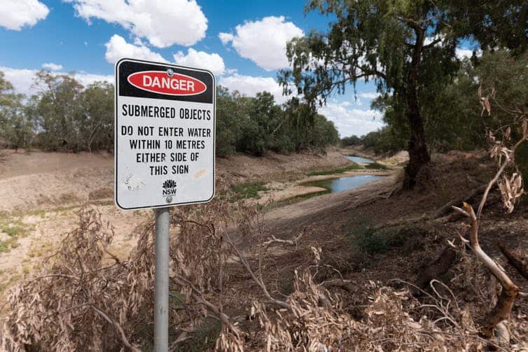 A sign of former times at Wilcannia: the Darling River recedes into the distance.