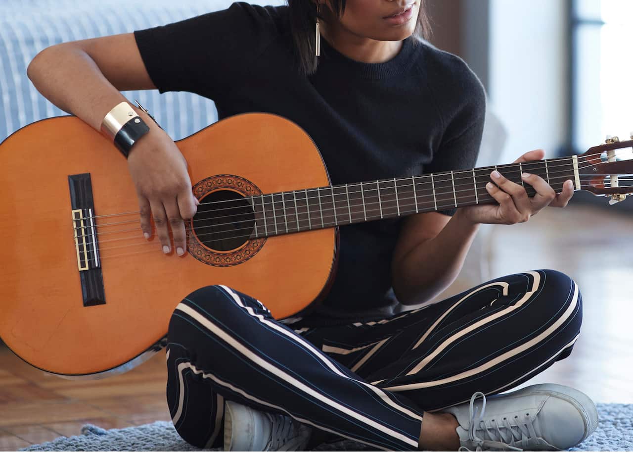 Female influencer recording for video blog with guitar lesson