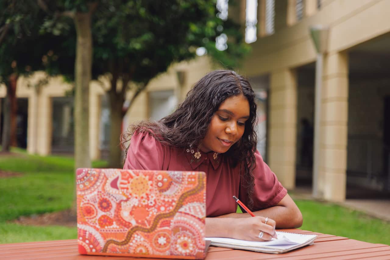 Female Aboriginal Australian Student Working On Laptop