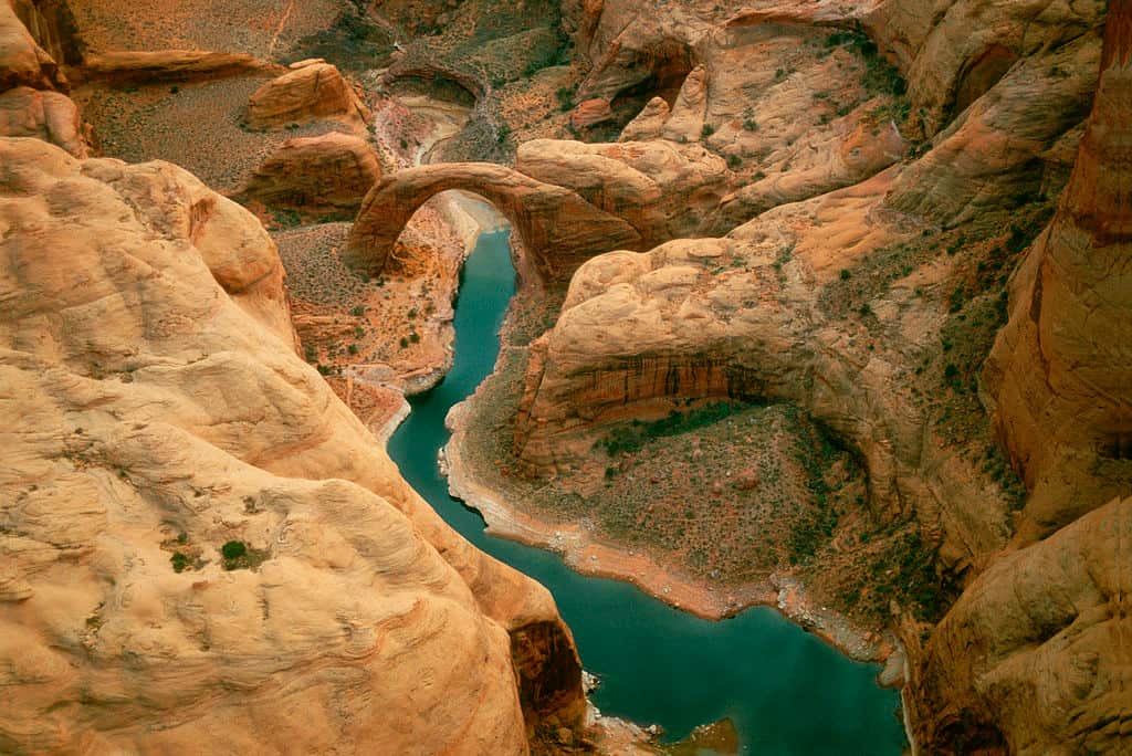 Aerial view of Rainbow Bridge, the world's largest known natural bridge, arcs over a tributary of Lake Powell Sacred landform to neighboring Native American tribes Rainbow Bridge National Monument, Glen Canyon National Recreation Area, Arizona, USA