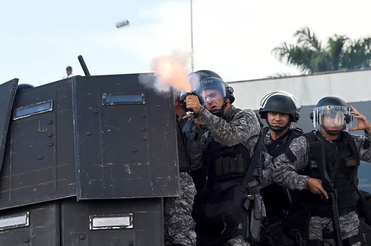 Riot police fire tear gas at Brazilian indigenous people from diverse ethnic groups during the annual march for their rights, in Brasilia, on April 25, 2017. 
