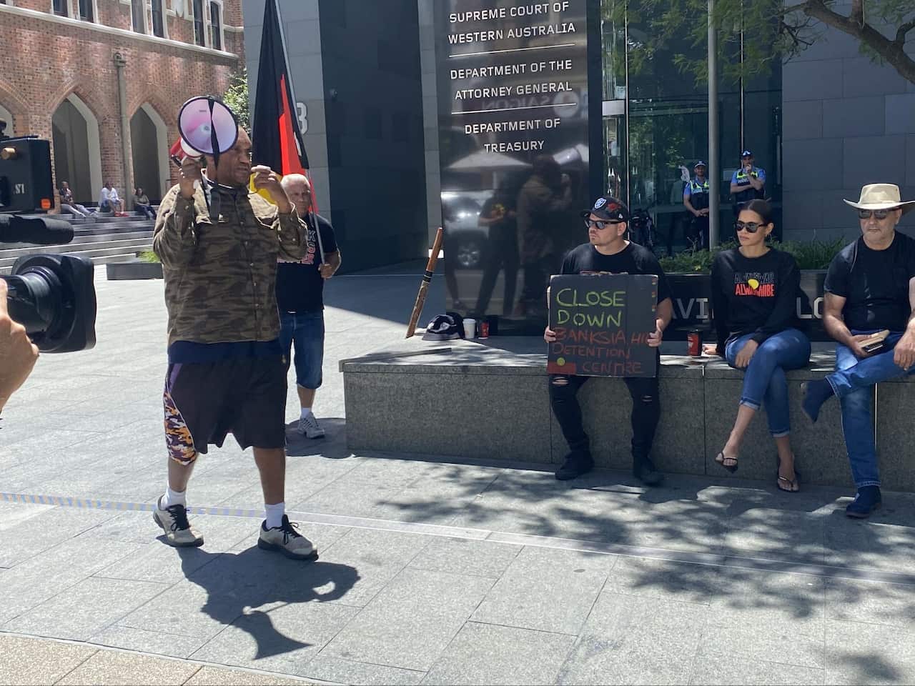 (Desmond Blurton speaking to the crowd outside the corrective services building.