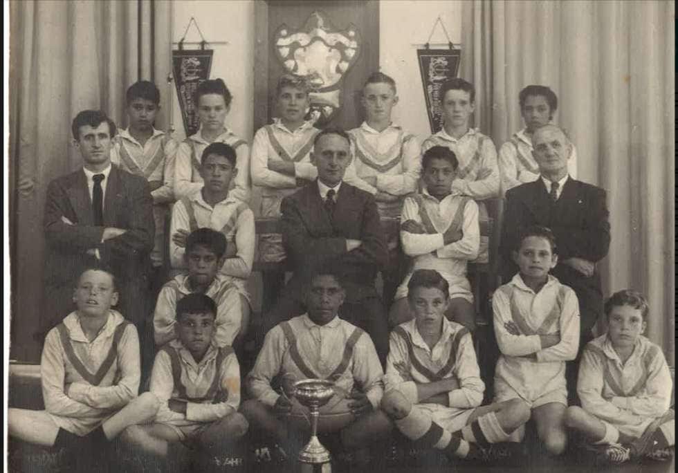 A naturally talented athlete, Uncle Les (bottom middle behind trophy) captained his junior rugby team before he took up boxing.