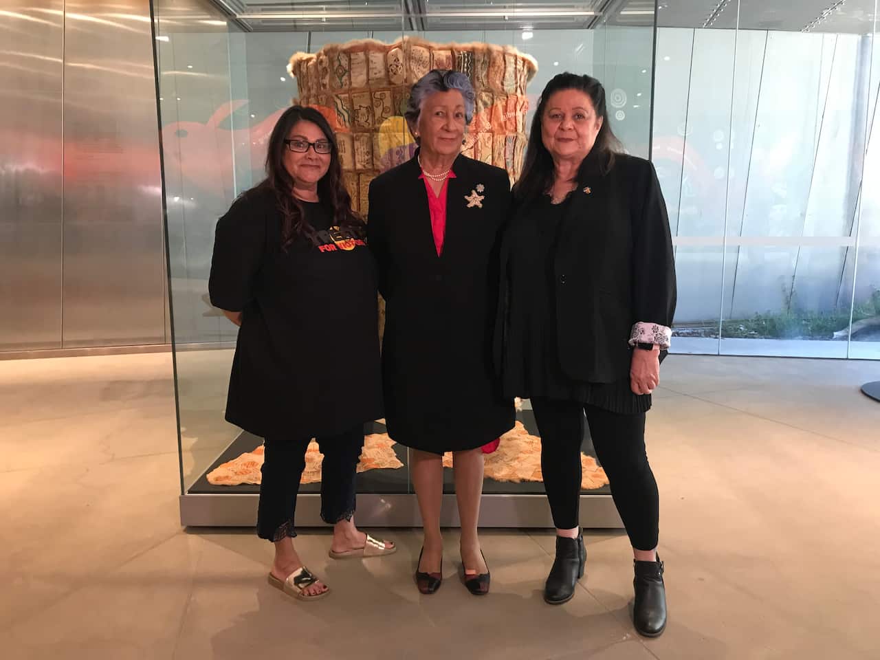 Coordinating artist Gina Bundle, Treaty Working Group co-Chair Aunty Eleanor Bourke, and Treaty Advancement Commissioner Jill Gallagher with the cloak.