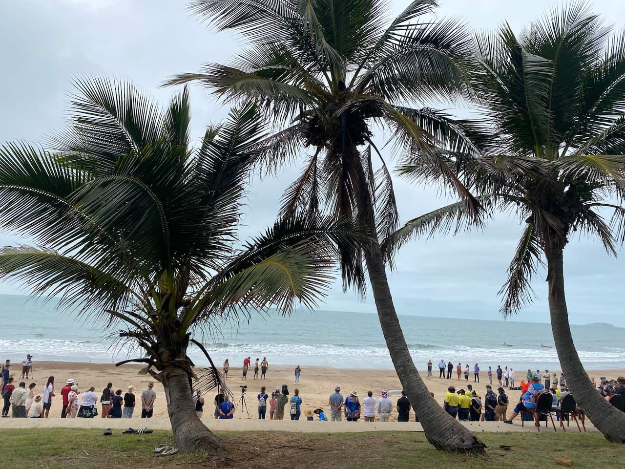People form a semi-circle on the beach