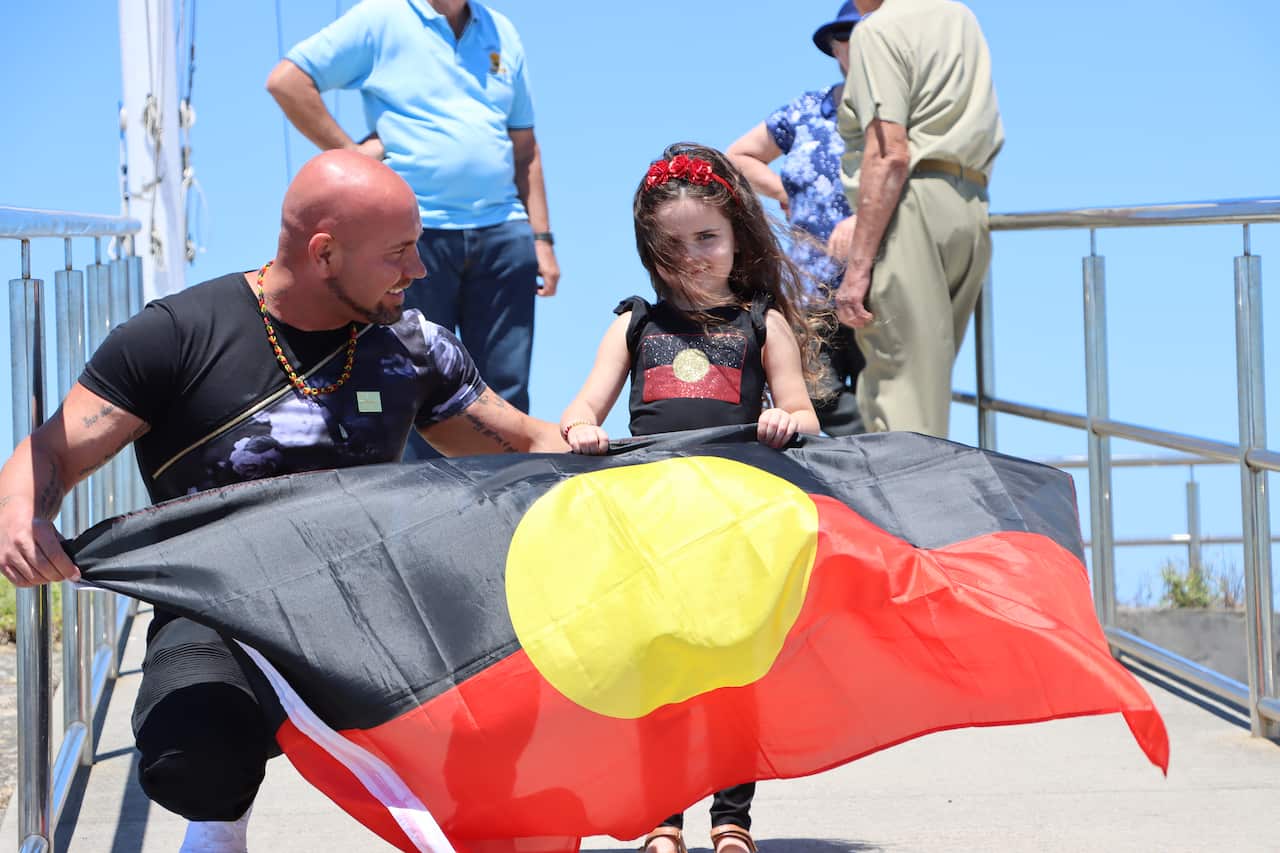 Brett and Isla Johnson with the Aboriginal flag.