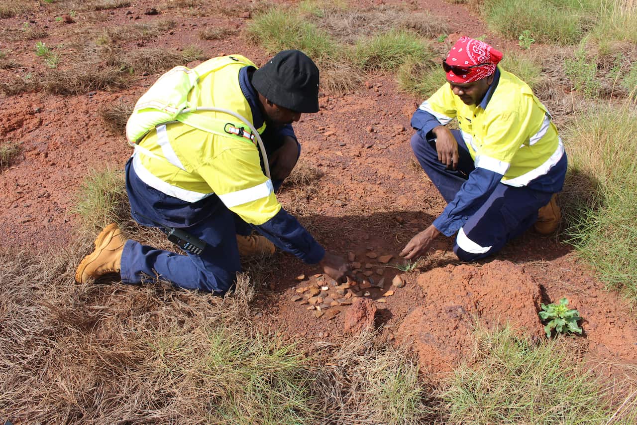 PKKP traditional owners examining artefacts on country in the Pilbara region of Western Australia.