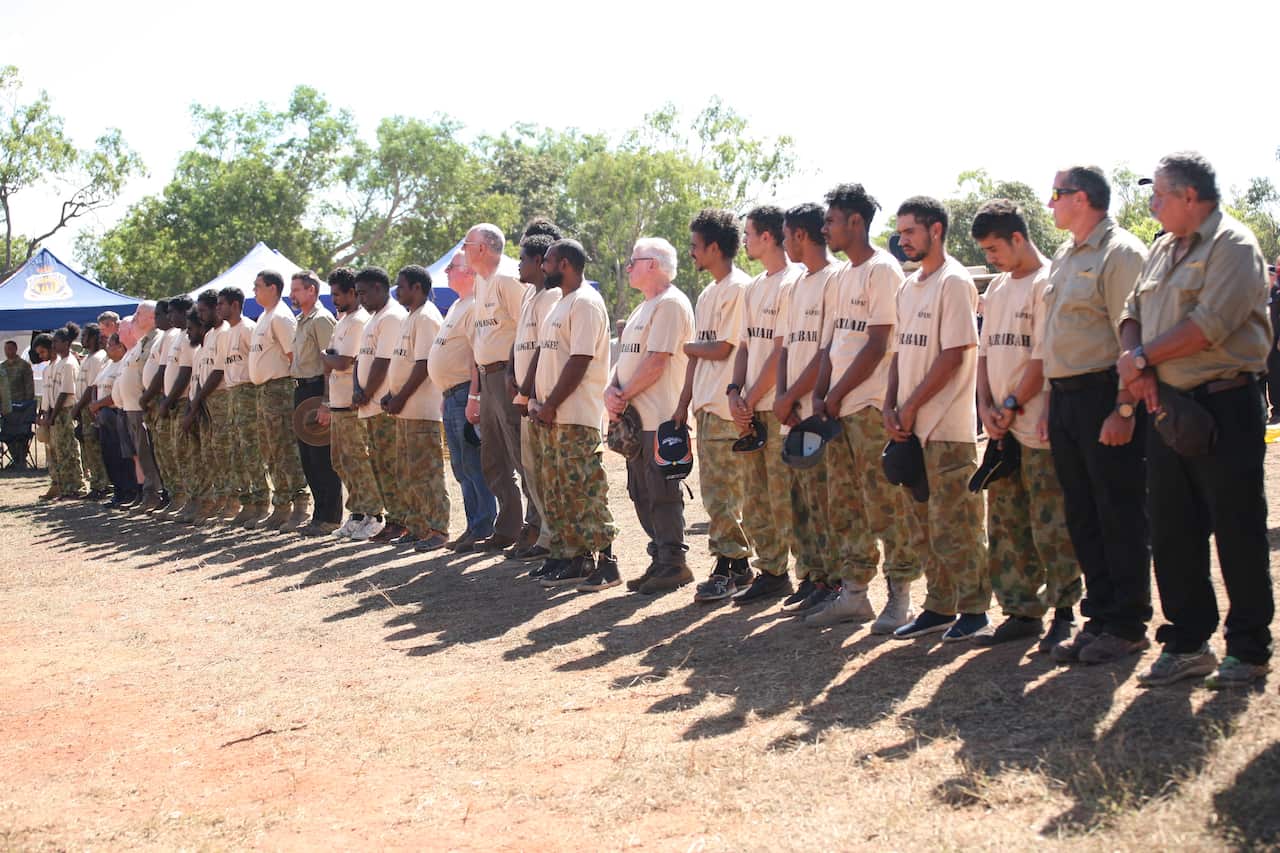 Kapani Warriors, both young Aboriginal men and war veterans stand side-by-side before the start of the Kapani Cup, Aurukun, 13 July, 2019. 