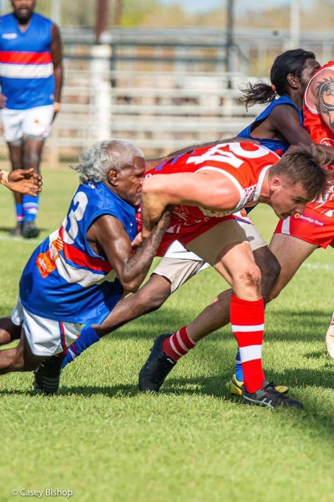 Keith Rogers cops an elbow to the face as he lays a tackle during a match at Nitmiluk Oval.