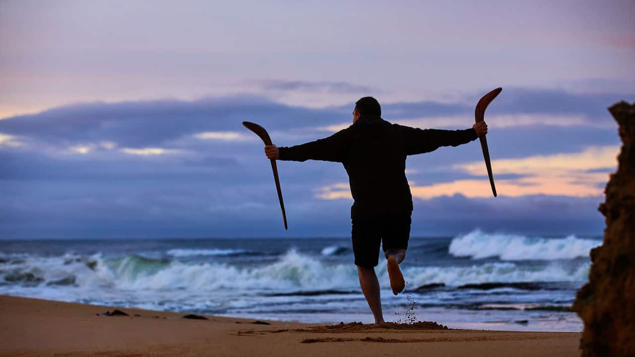 lowell hunter dancing in the sand with sticks at sunset