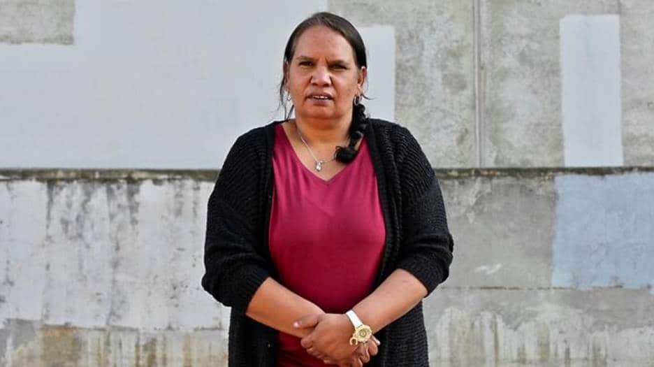 A mid shot of megan krakouer with her hands held in front of her. 