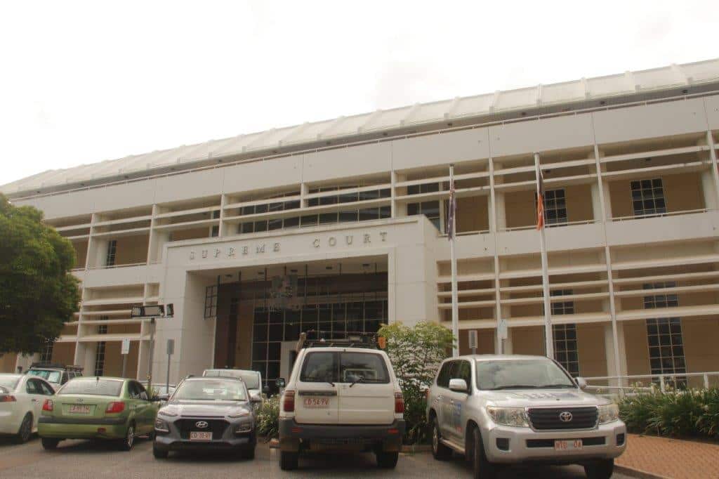 An exterior shot of the Supreme Court of the Northern Territory with cars parked in front. 
