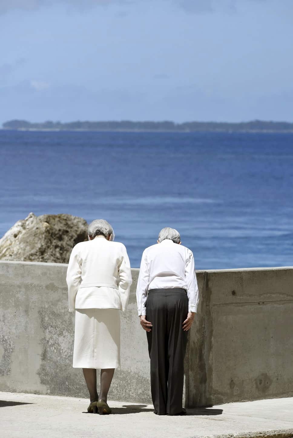 At the cenotaph on Palau’s Peleliu Island, Japan’s Emperor Akihito and Empress Michiko bow towards the battleground of Angaur Island.