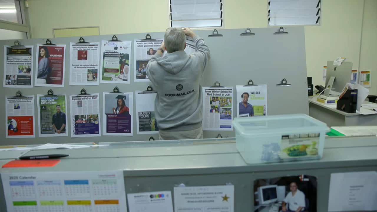 Koori Mail staff member Stuart Corlett hangs up the pages ready for printing