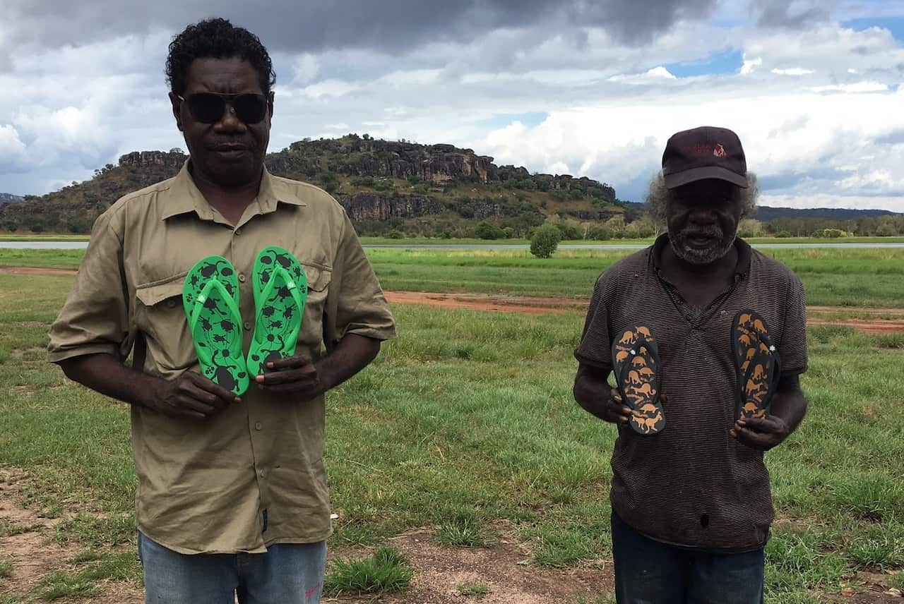Benson (Isaiah) Nagurrgurrba and Graham Badari with their respective thong designs ('Turtles' and 'Stone Country Animals').