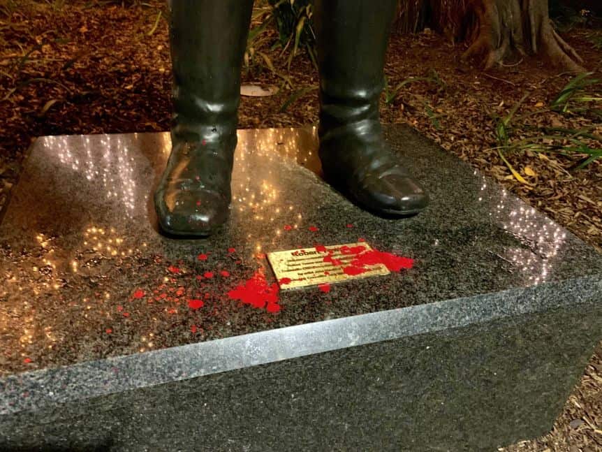 Red paint droplets between the feet of the Robert Towns statue. 