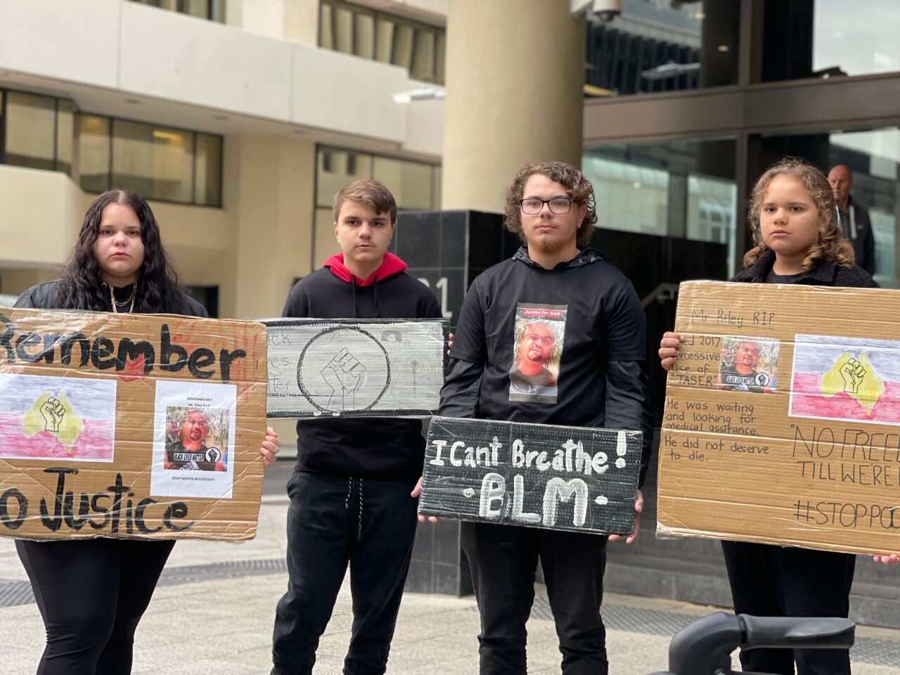Chante Riley, Sheldon Riley, Chad Riley and Shenelle Riley hold signs calling for justice four years after the death of their father Mr Riley, who stopped breathing after being tasered 10 times in two minutes in Perth in 2017.