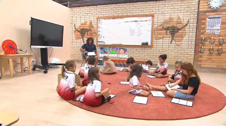 Students sitting in a class room drawing