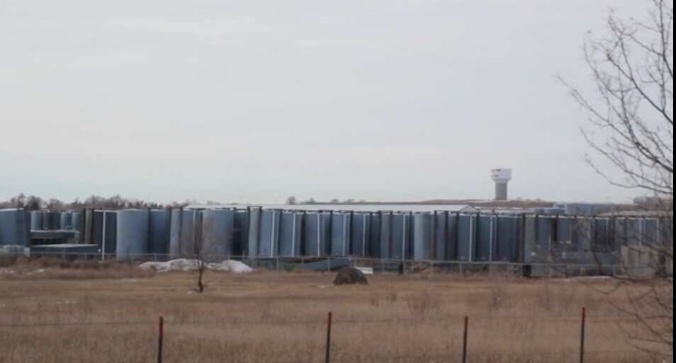 A water tower looms nearby a chemical dumping site in a First Nations community in North Dakota where fracking has been taking place since 2006 and causing many in the community to become ill.