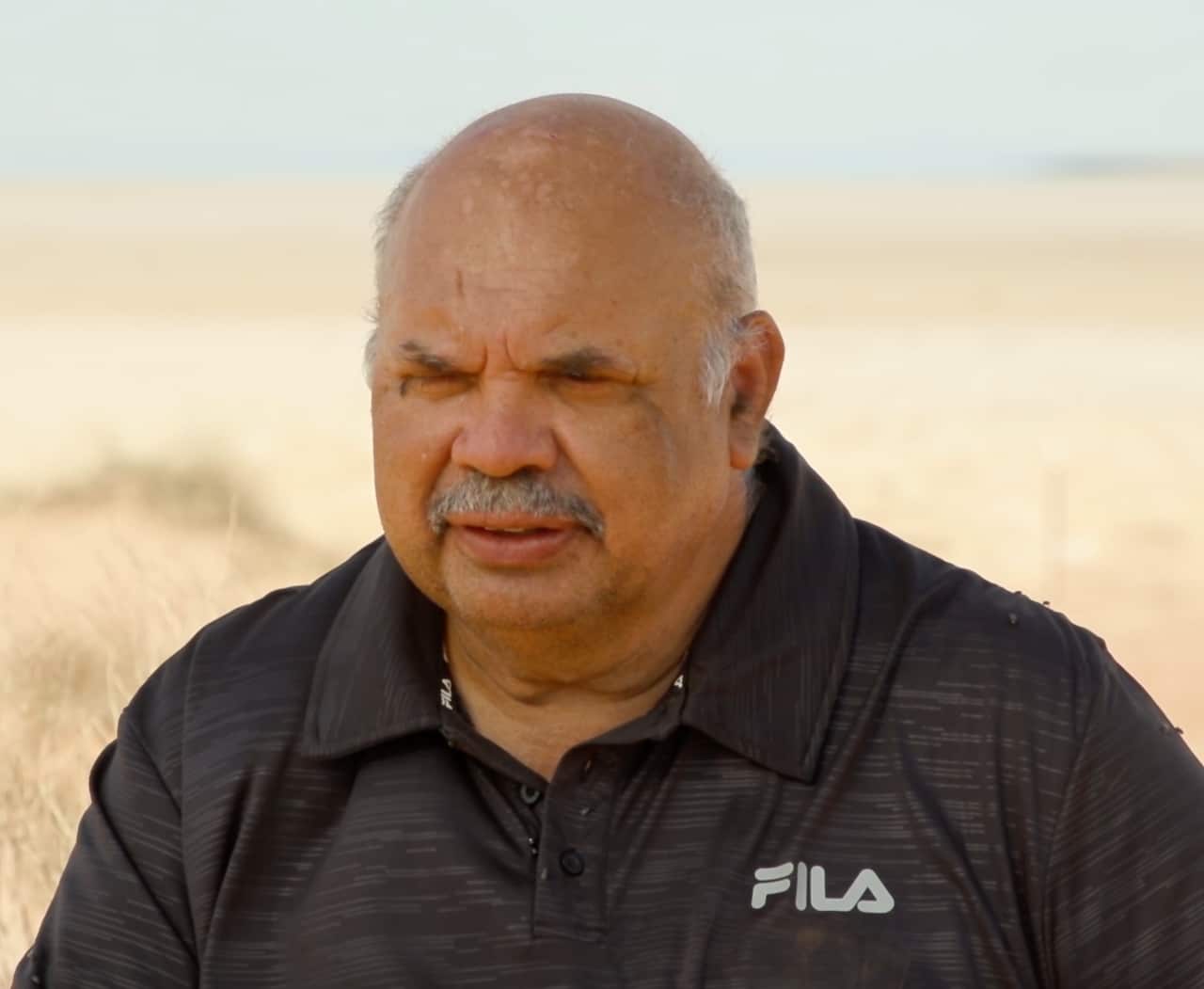 Kuyani man, Tony Clark sits on the edge of Lake Torrens, explaining the significance of the area and, just 200 metres away from a drilling rig. 