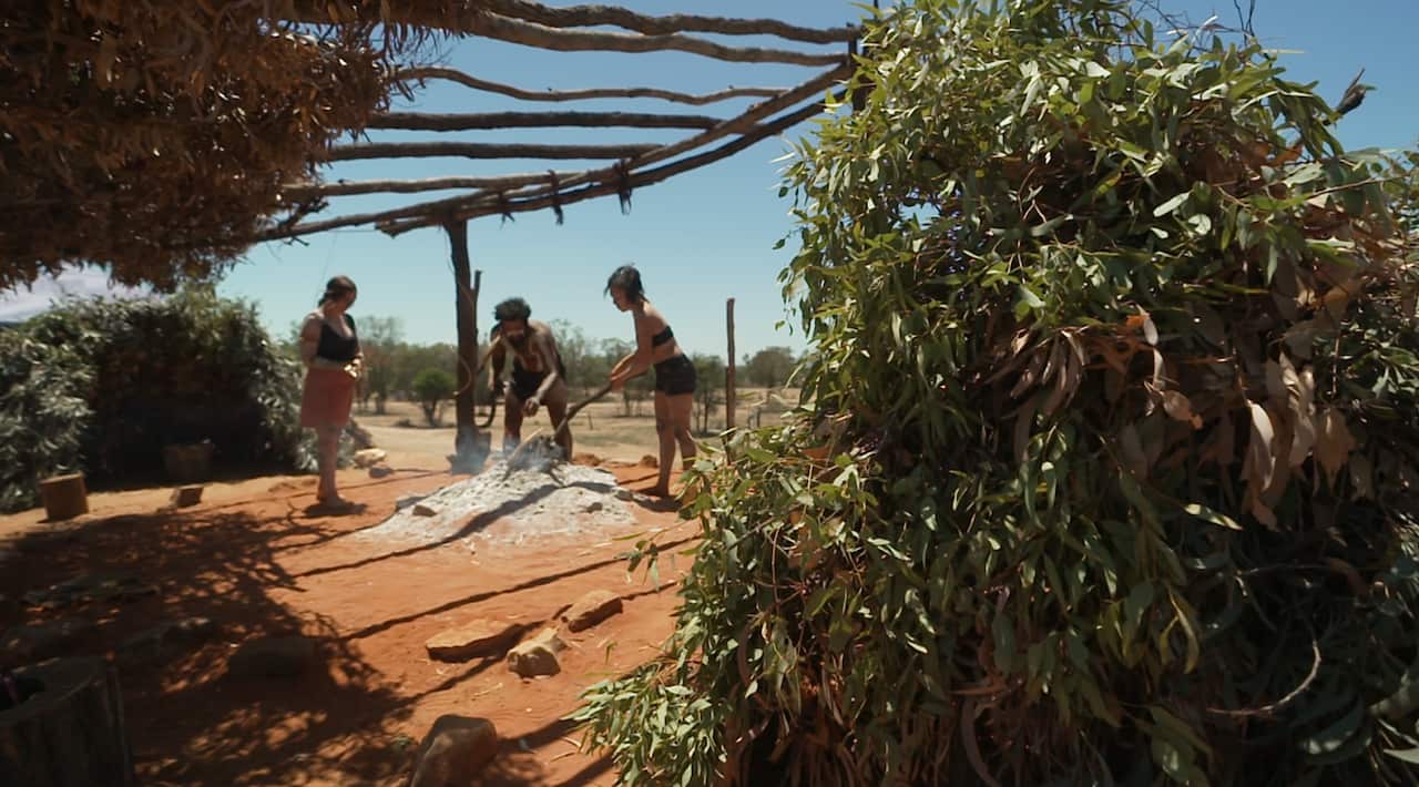 Coedie McAvoy and Miesha McAvoy tend the ceremonial fire at the camp.