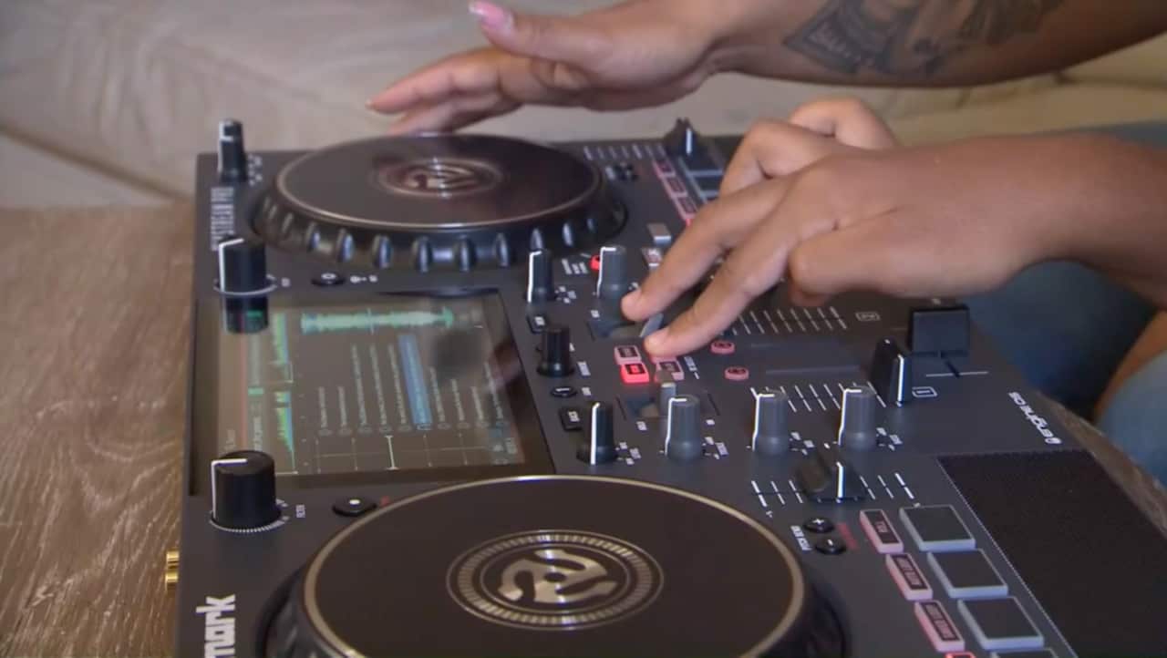Melanie and Angel playing on their DJ equipment. 
