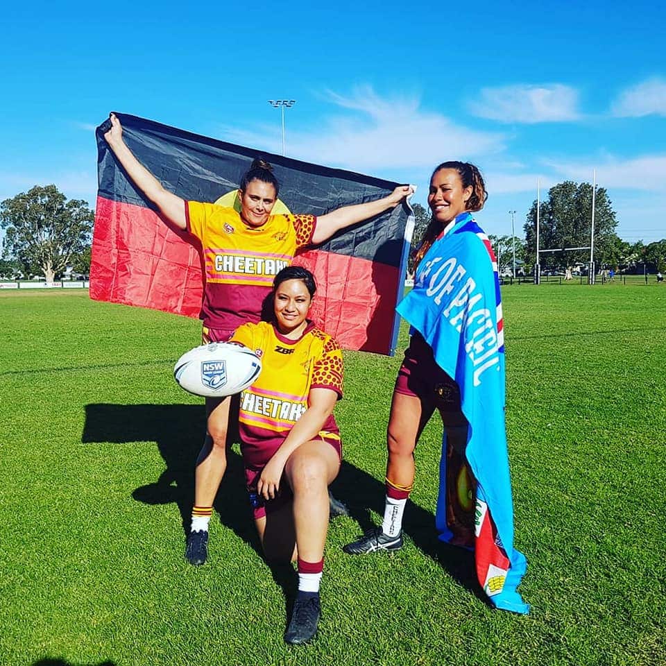 Coach, Sheridan Noble stand with an Aboriginal flag next to two player on her team following the racial abuse they copped in July at Dora Creek. 