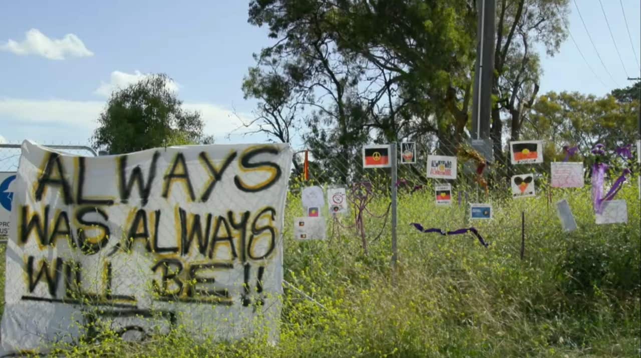 Signs of protest and solidarity on the fence of the proposed go-kart track site.