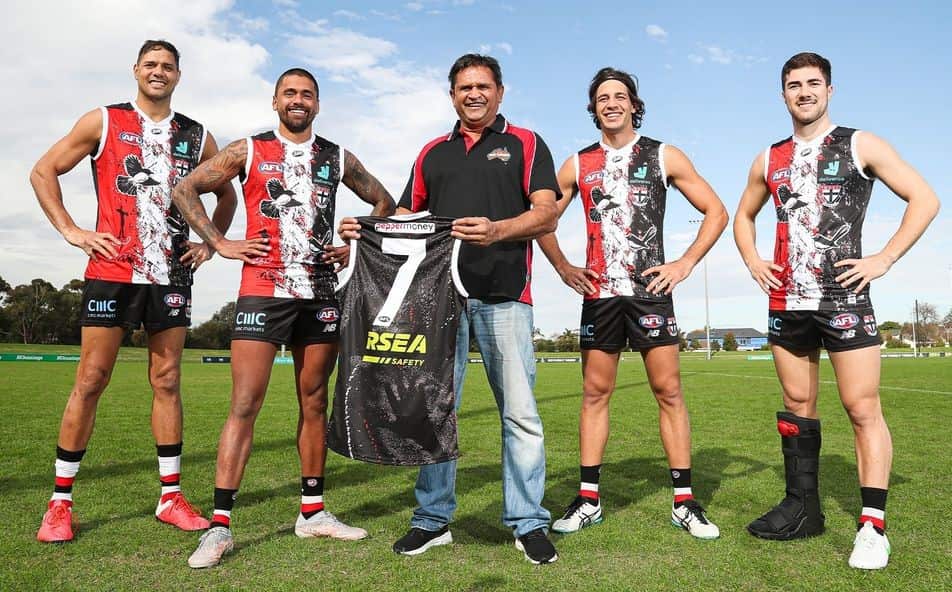 Nicky Winmar (centre) proudly shows off hid design on the St Kilda website.