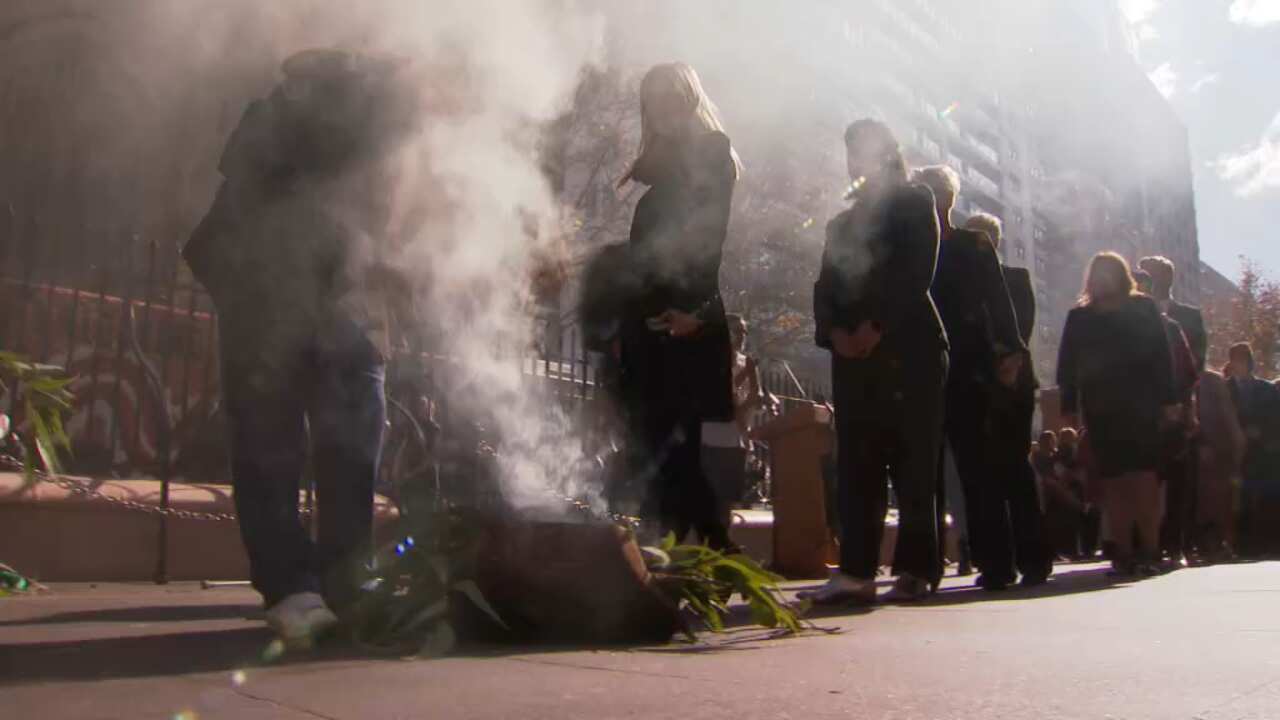A procession walks through smoke in a cleansing ceremony 