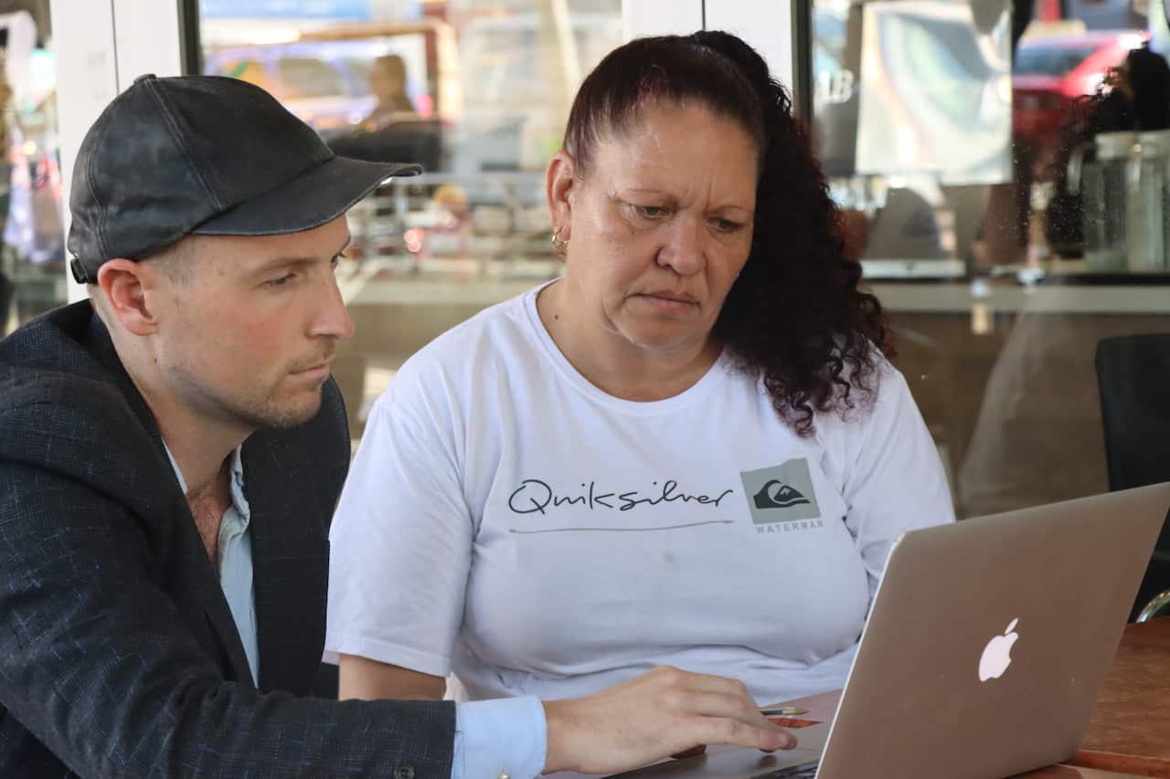 Tania Hansen and Jesse Noakes look at a computer