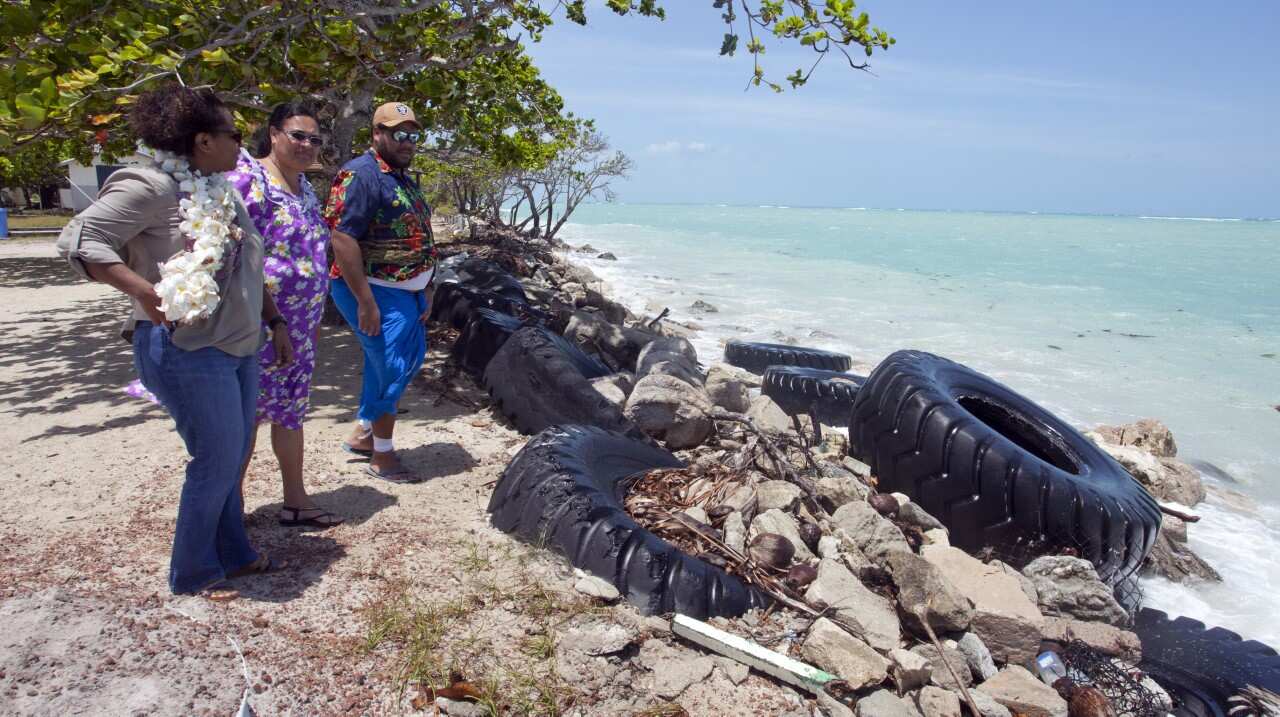 Localtorress strait islanders inspect a beach claimed by rising sea levels