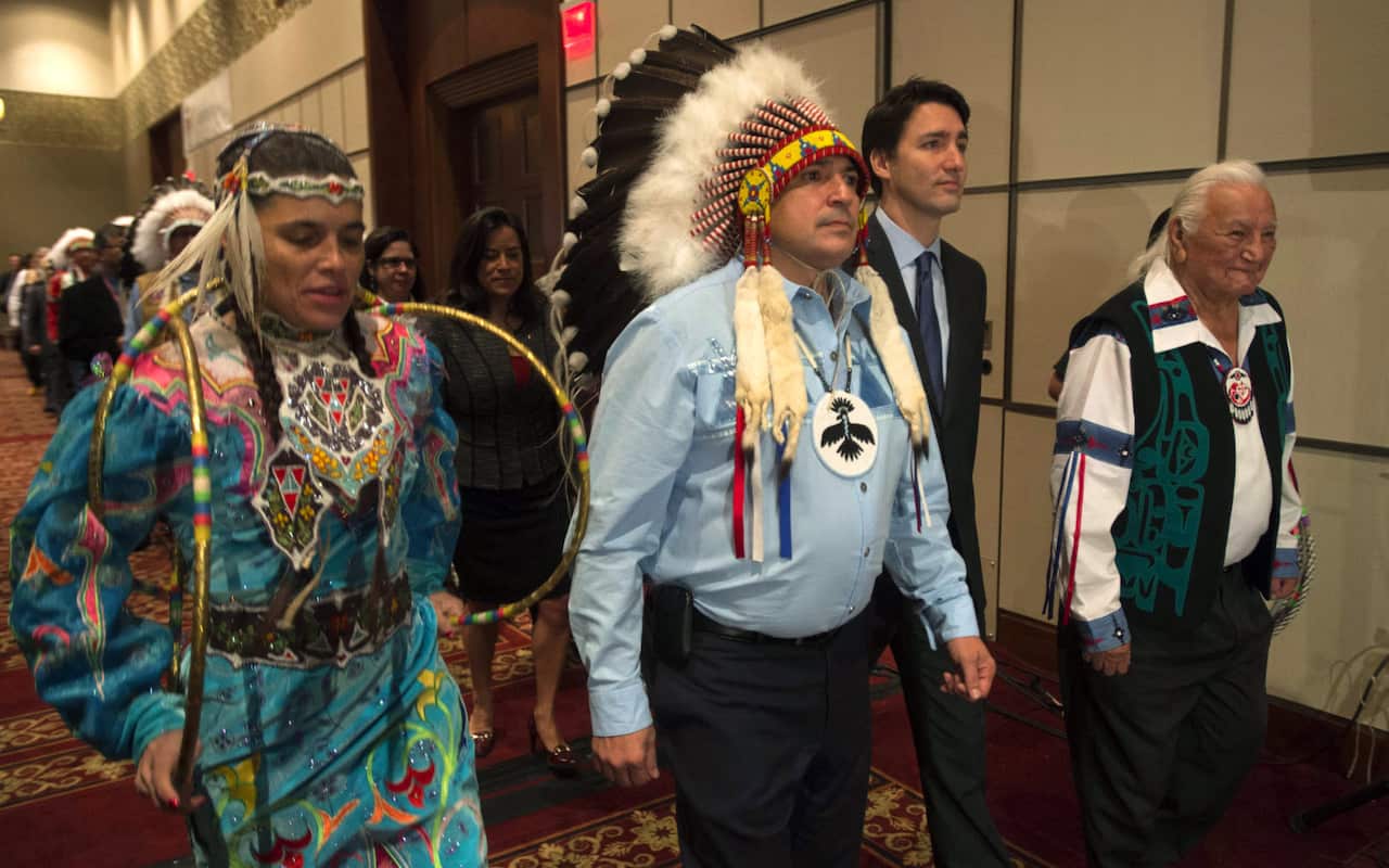 Aboriginal dancers and elders walk with Canada's Prime Minister Justin Trudeau and AFN National Chief Perry Bellegarde as they enter the hall at the Assembly of First Nations Special Chiefs Assembly in Gatineau, Quebec