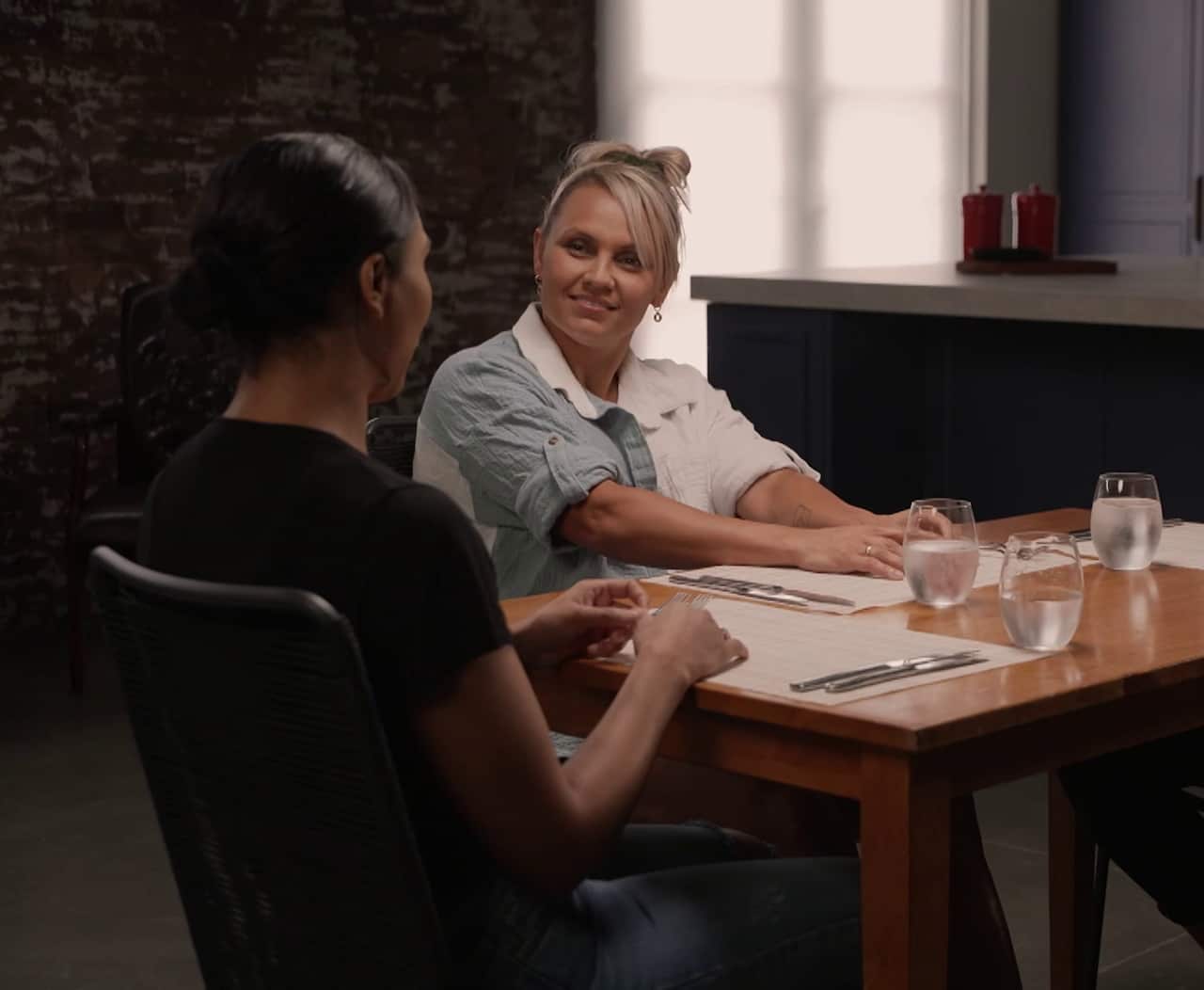bo de la cruz and shanell dargan sitting at a table