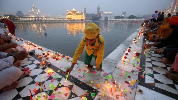 A Sikh boy lights candles in India for Diwali festival