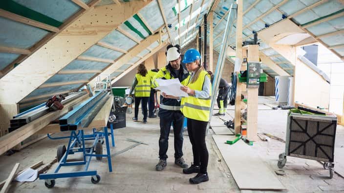Construction managers planning while standing in messy site