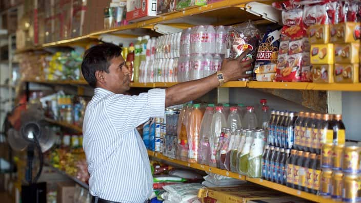 Rohingya refugee Kobir Ahmed working inside a grocery store.