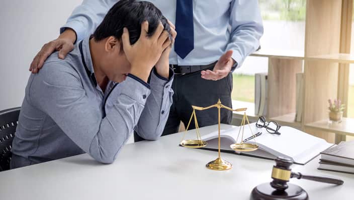Midsection Of Lawyer Consoling Depressed Client In Courtroom