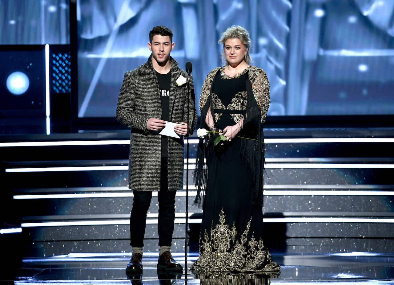 Nick Jonas and Kelly Clarkson both sported white roses on stage at the Grammys.