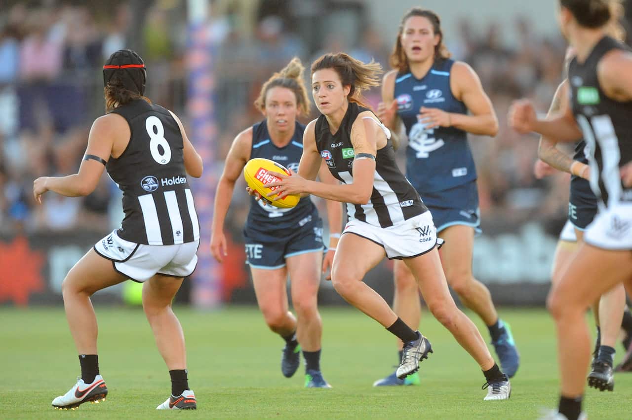 Stephanie Chiocci of Collingwood (centre) runs with the ball during the round 1 AFLW match between the Carlton Blues and the Collingwood Magpies at Ikon Park in Melbourne, Friday, Feb. 3, 2017. (AAP Image/Joe Castro) NO ARCHIVING, EDITORIAL USE ONLY