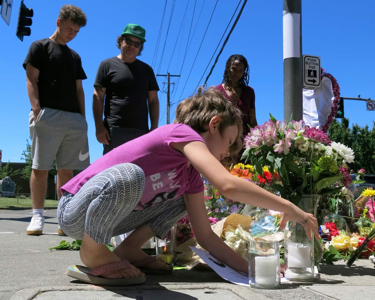 Coco Douglas, 8, leaves a handmade sign and rocks she painted at a memorial in Portland for two bystanders stabbed to death following an anti-Muslim attack. 